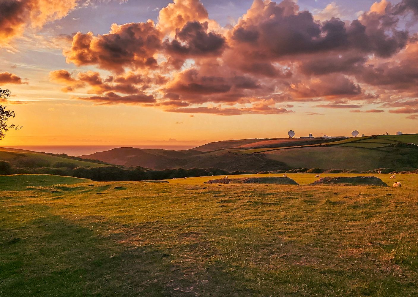 Sunset with fluffy clouds over rolling hills landscape near Duckpool on the North Cornwall coast.