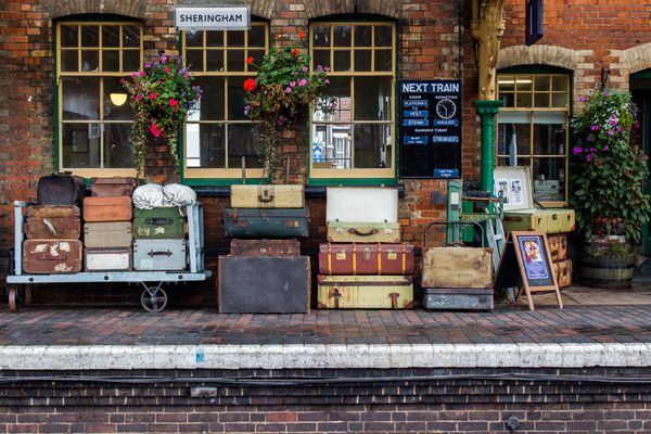 Luggage stacked up on station platform.