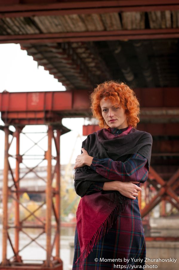 Red haired female in an abandoned area near a bridge