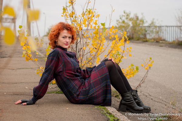 Red haired female in an abandoned area near a bridge