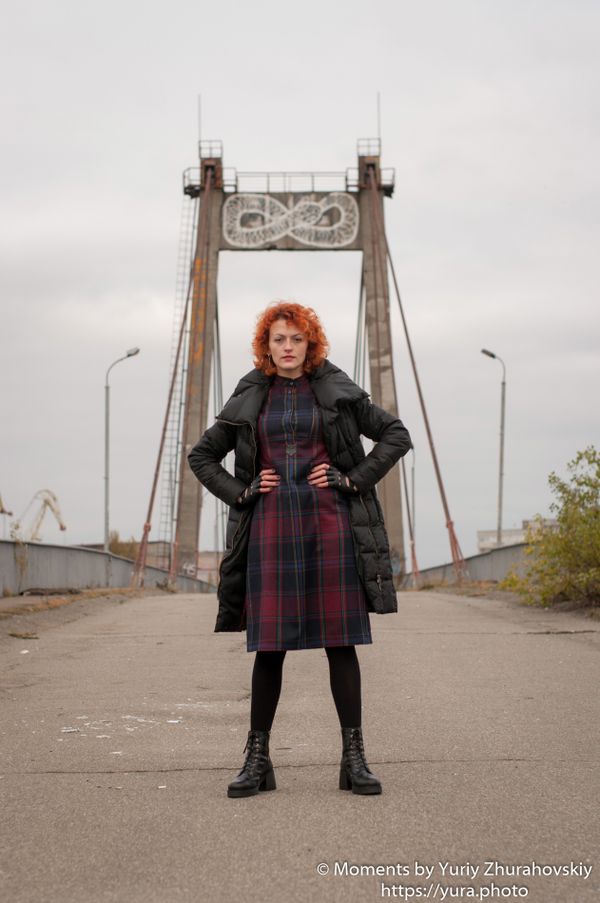 Red haired female in an abandoned area near a bridge
